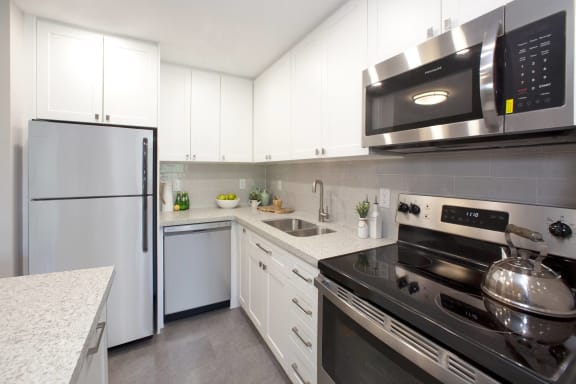 a kitchen with white cabinets and stainless steel appliances