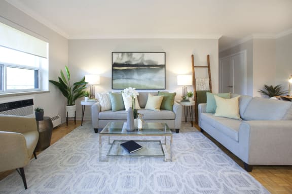 a living room with couches and chairs and a glass coffee table