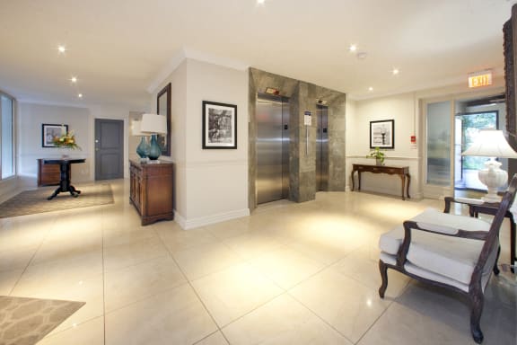 a large living room with a large tiled floor and a stainless steel elevator