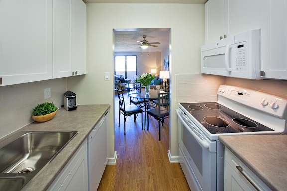 a kitchen with a stove and a sink and a dining room