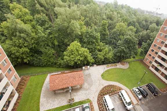 an aerial view of a building and a parking lot with trees