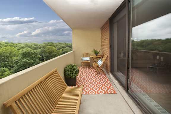 a balcony with two wooden benches and a view of the trees