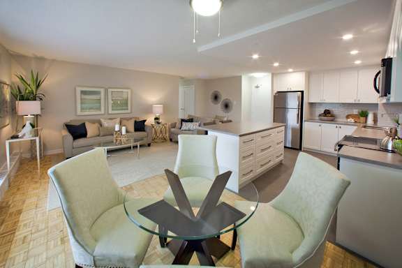 a living room and kitchen with a table and chairs