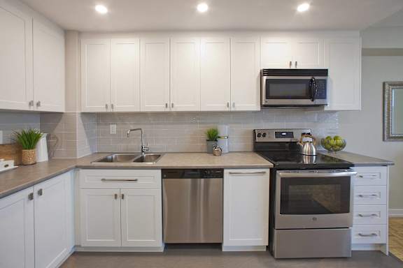 a kitchen with white cabinets and stainless steel appliances