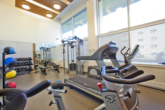 a gym with exercise equipment and large windows