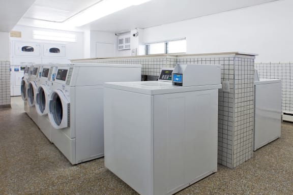 a row of washers and dryers in a laundry room