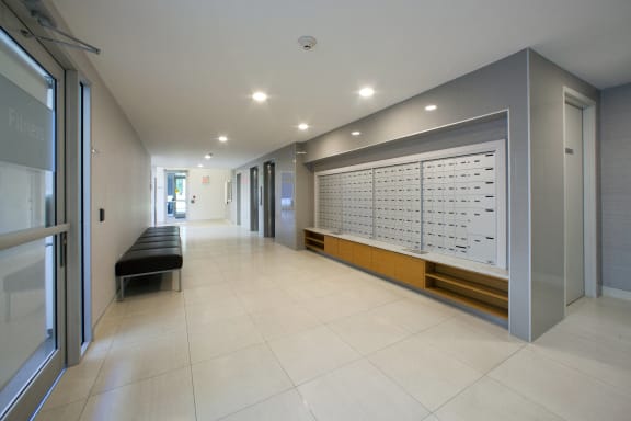 a long hallway with a bench and a large storage unit on the wall