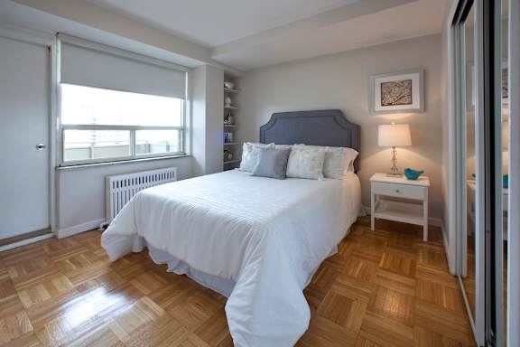a bedroom with a bed and a window and a wooden floor
