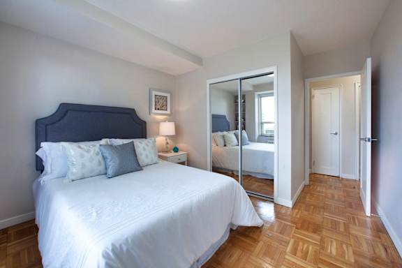 a bedroom with a large white bed and a mirror