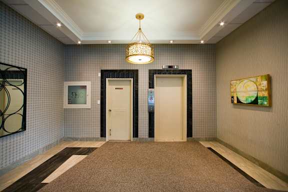 a hallway with two doors and a chandelier