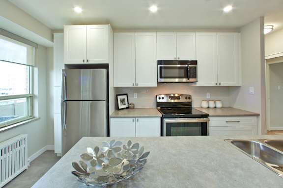 a kitchen with white cabinets and stainless steel appliances