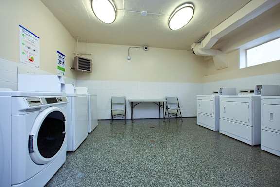 a laundry room with washing machines and a table with chairs