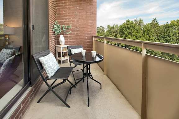 a balcony with a table and chairs and a window