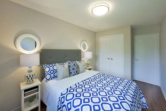 a bedroom with a large bed with blue and white comforter and two lamps