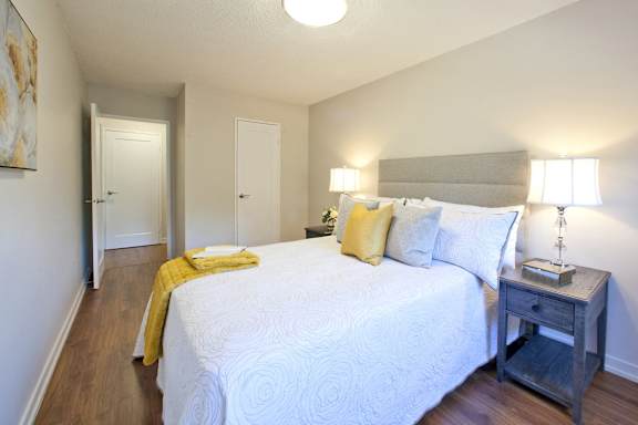 a bedroom with a white bed and a yellow blanket