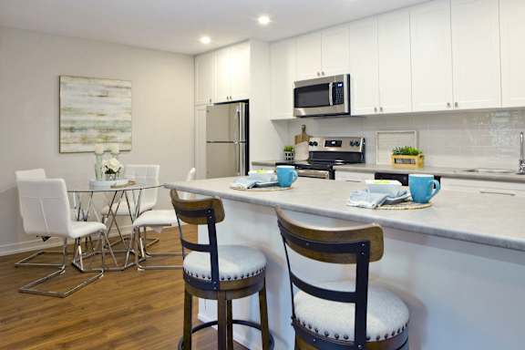 a kitchen and dining area with a counter and chairs