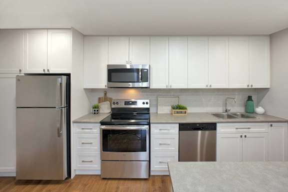 a kitchen with stainless steel appliances and white cabinets