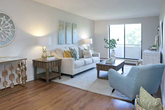 a living room with a couch and a chair and a window