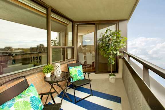 a balcony with two chairs and a table