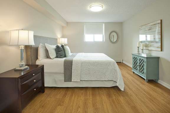 a bedroom with a bed and a dresser and a window