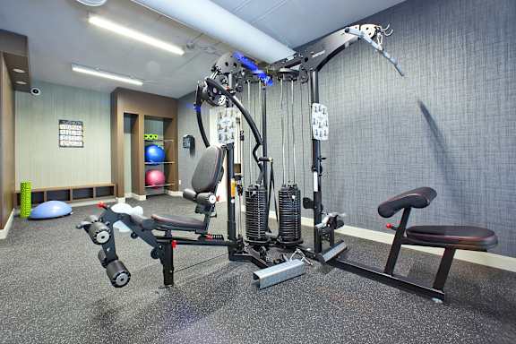 a gym with weights and cardio equipment in a room