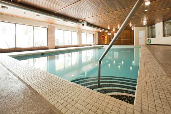 a swimming pool in a building with a railing on the side