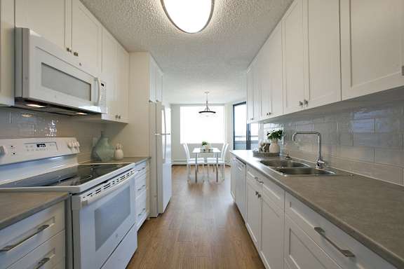 a kitchen with white cabinets and stainless steel appliances