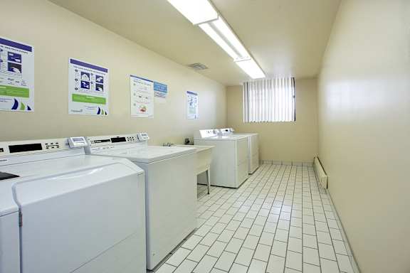 a laundry room with three washers and three washing machines