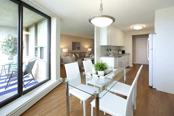 a living room and dining room with a glass table and white chairs