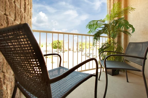 a balcony with chairs and a view of the ocean