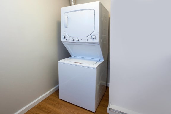 a washer and dryer in a room with a wooden floor