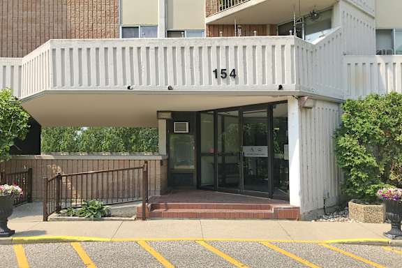the front entrance of an apartment building with a ramp and a balcony