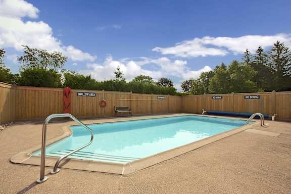 a swimming pool with a fence around it and a blue sky