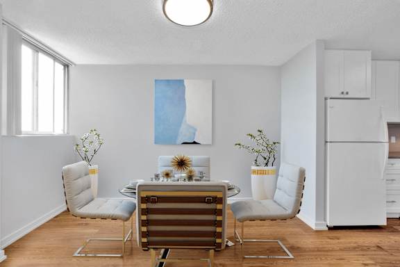 a dining room with a table and chairs and a refrigerator