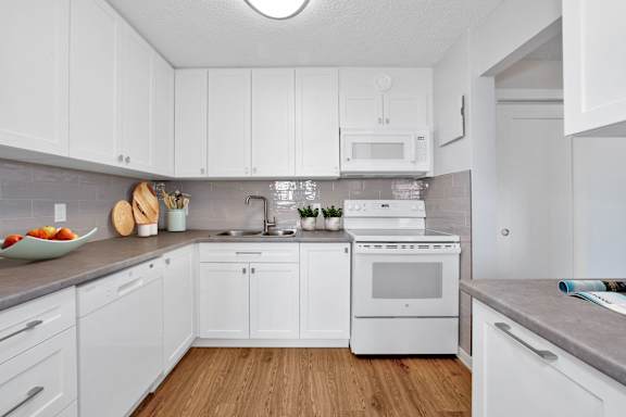 a white kitchen with white appliances and white cabinets