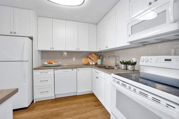 a white kitchen with white appliances and white cabinets