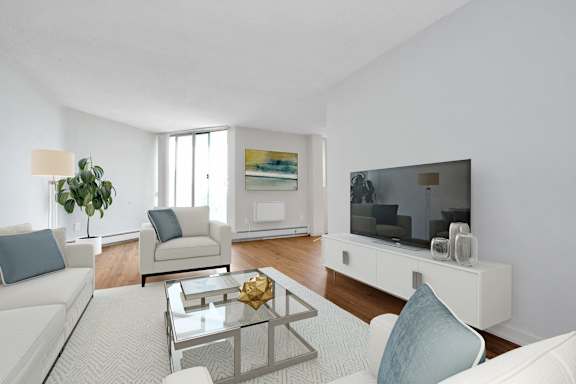 a living room with white furniture and a large tv