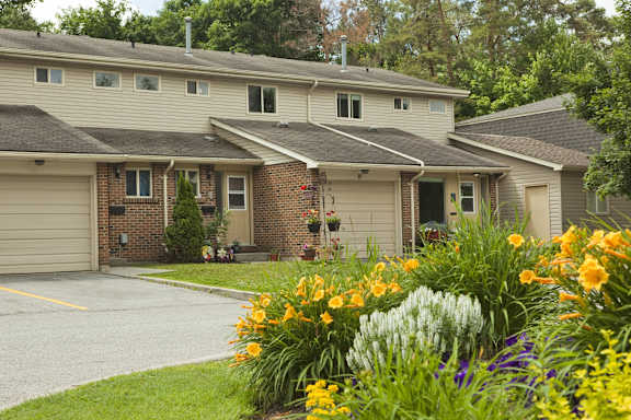 the front of a house with a yard full of flowers