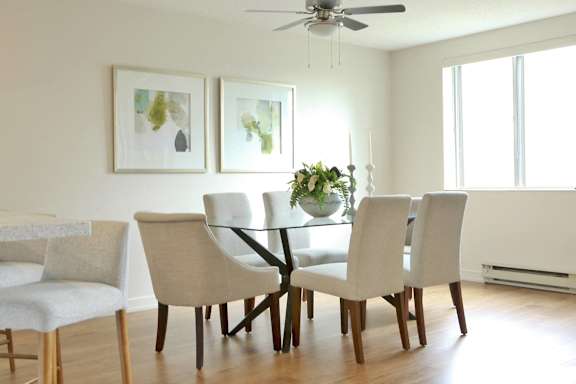 a dining room with a table and chairs and a ceiling fan