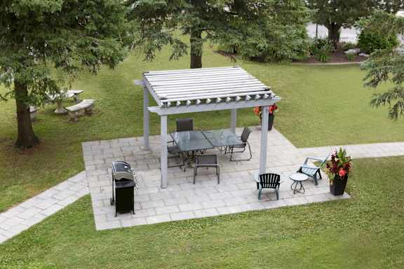 a patio with a pergola and a table and chairs