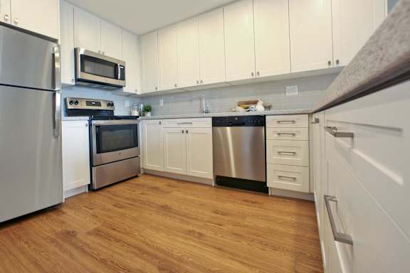 a kitchen with white cabinets and stainless steel appliances