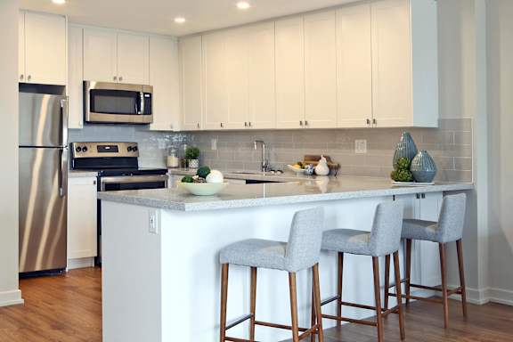 a kitchen with a large island with three bar stools