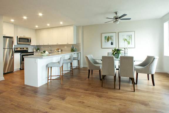 a kitchen and dining room with white cabinets and a table and chairs
