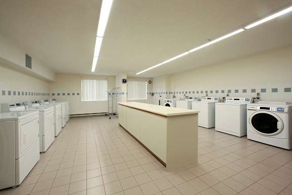 a washer and dryer room with a row of washing machines