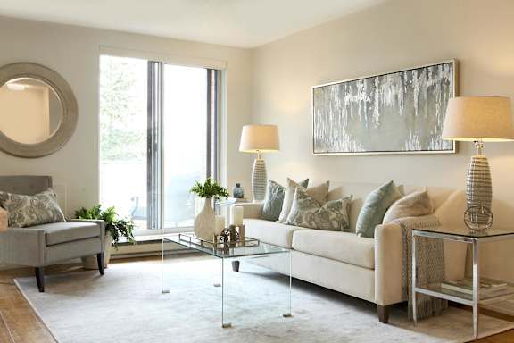 a living room with a white couch and a glass table