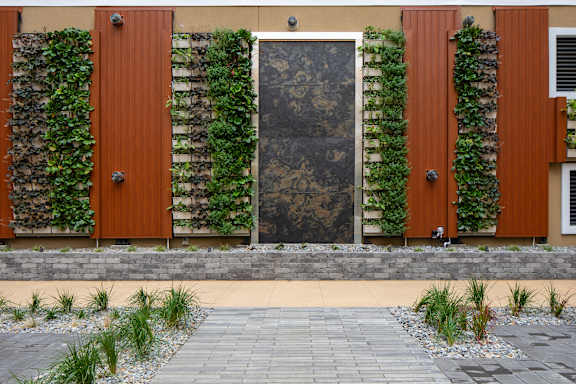 the facade of a building with a wall covered in green plants