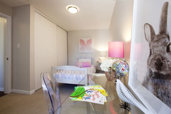 a living room with a table and a rabbit in the window