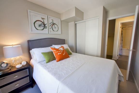 a bedroom with a large white bed and two bikes on the wall