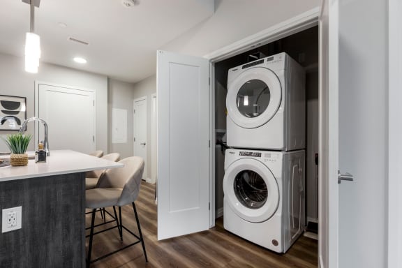a front loading washer and dryer in a closet in a kitchen