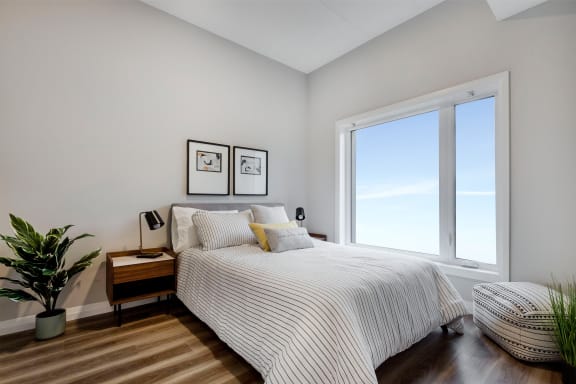 a bedroom with a bed and a large window